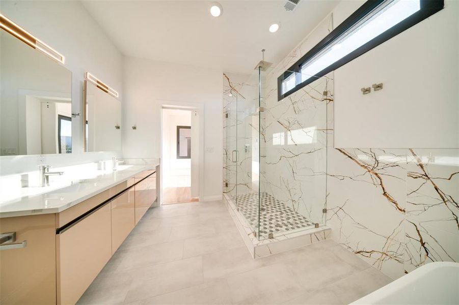 Bathroom with vanity, a healthy amount of sunlight, independent shower and bath, and tile patterned flooring