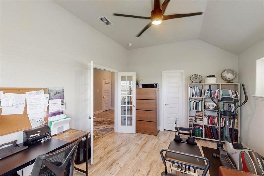 Office featuring vaulted ceiling, french doors, ceiling fan, and light wood-type flooring