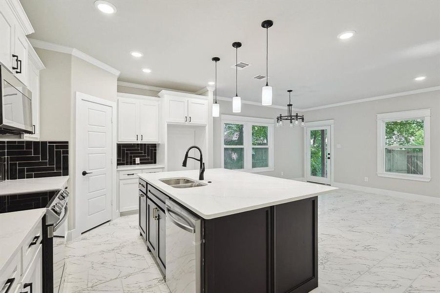 Kitchen with hanging light fixtures, light tile flooring, backsplash, and appliances with stainless steel finishes
