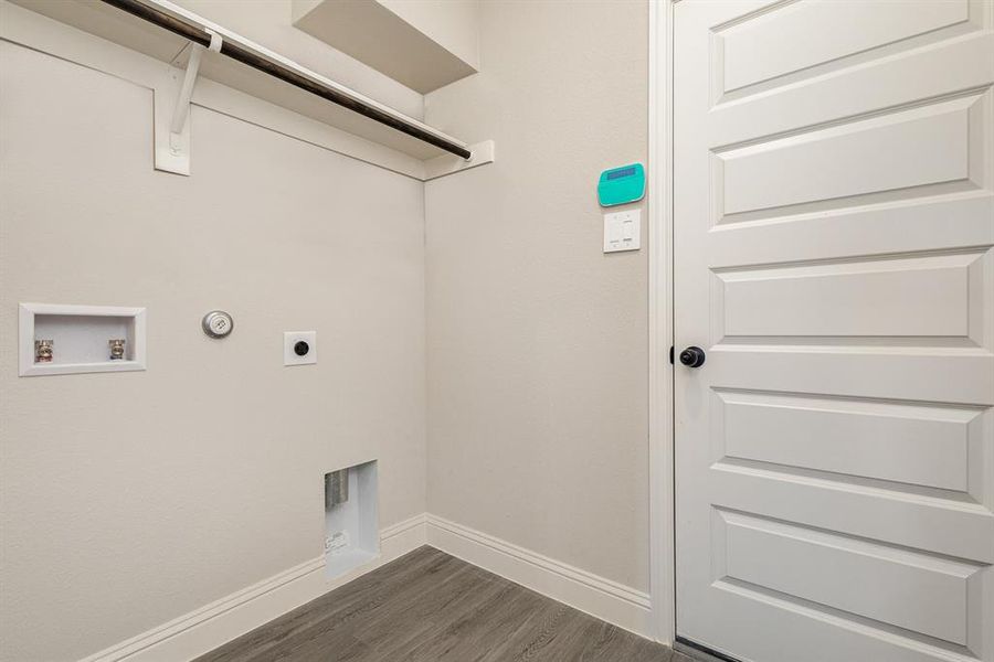 Clothes washing area featuring hookup for a gas dryer, hookup for an electric dryer, washer hookup, and dark hardwood / wood-style flooring