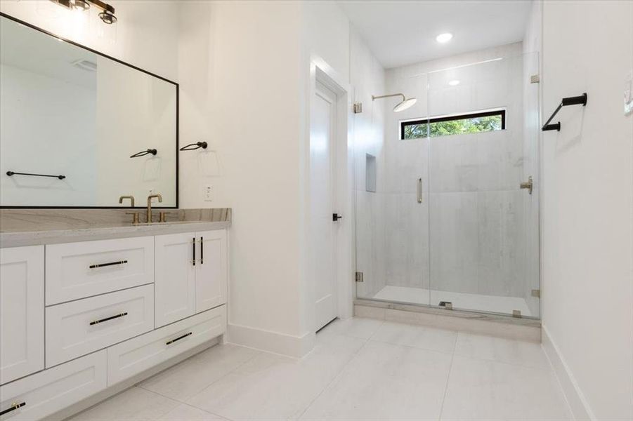 Bathroom with walk in shower, tile flooring, and large vanity