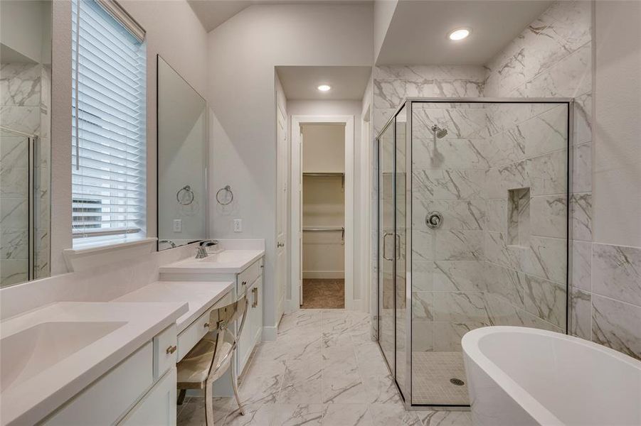 Bathroom with tile patterned floors, separate shower and tub, and double sink vanity
