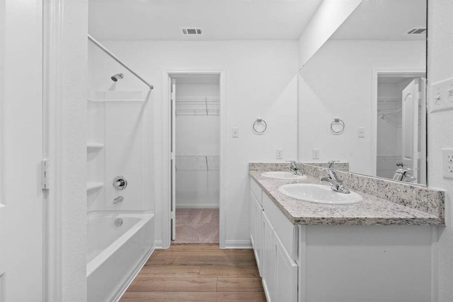 The primary bathroom includes granite countertops, double vanities, enclosed water closet and a walk-in closet.