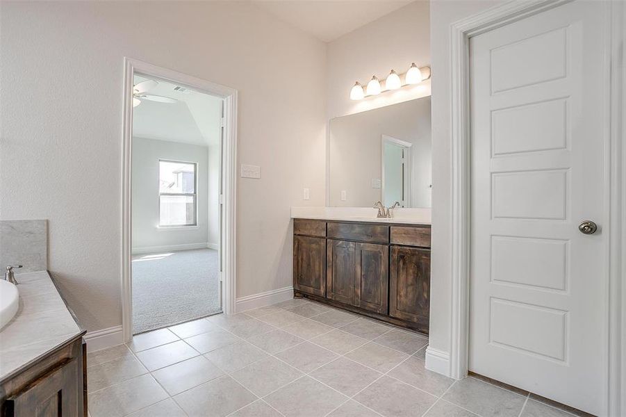 Bathroom featuring ceiling fan, vanity, and tile patterned floors