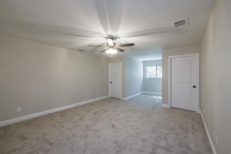 Carpeted empty room with ceiling fan