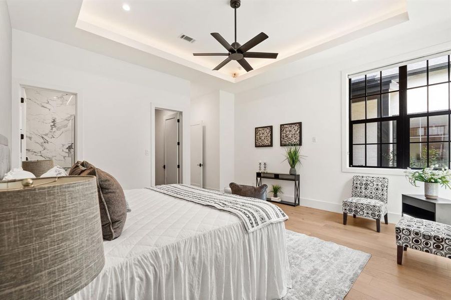 An additional view of the first floor bedroom featuring an en suite bathroom, oversized windows, recessed lighting and plenty of space for a seating area.