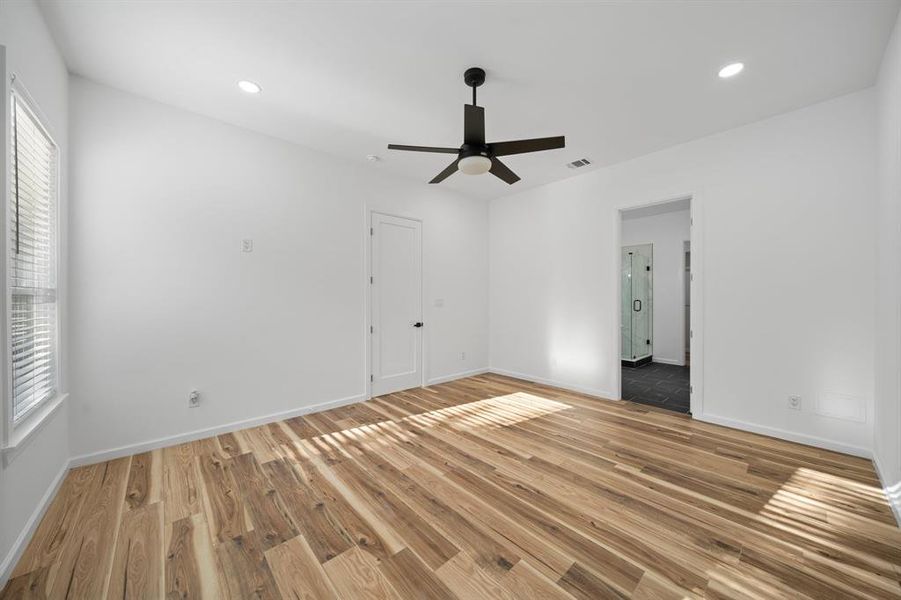 Empty room with plenty of natural light, ceiling fan, and hardwood / wood-style flooring