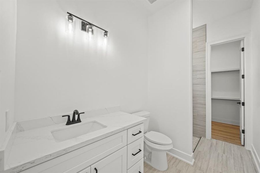 This bathroom features granite countertops, soft closing drawers, and tile floors. *mirror installation coming soon* Photos are from a similar unit in the development.