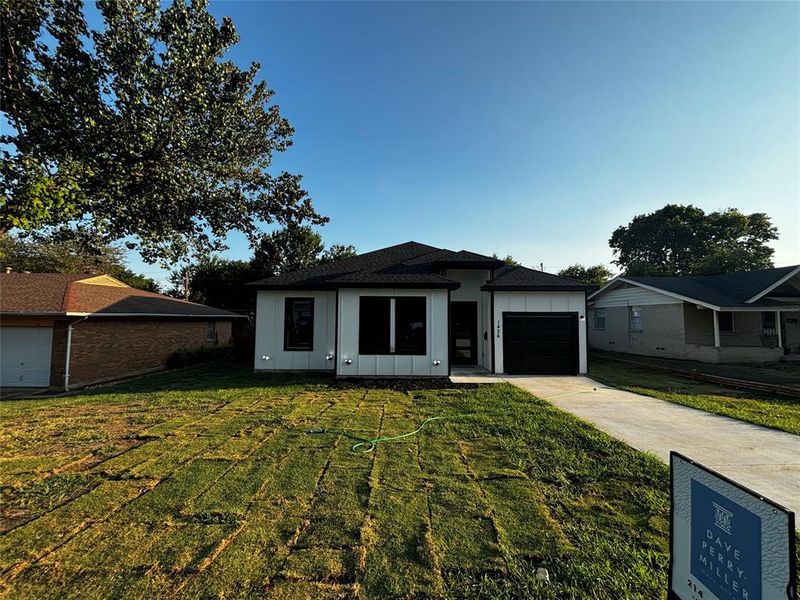 View of front of home featuring a garage and a front lawn