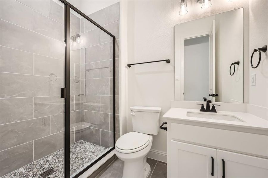 Bathroom featuring vanity, toilet, and an enclosed shower