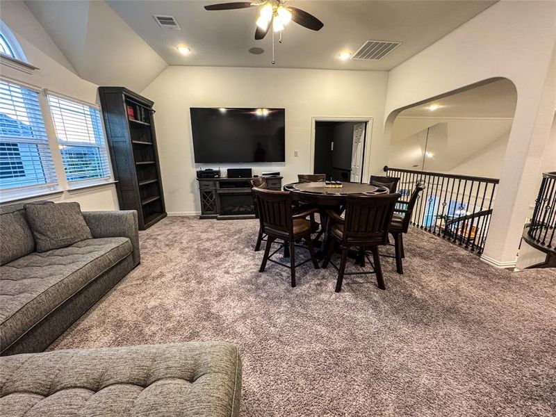 Dining area with lofted ceiling, carpet flooring, and ceiling fan