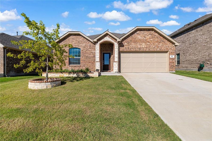 View of front of house featuring a garage and a front yard