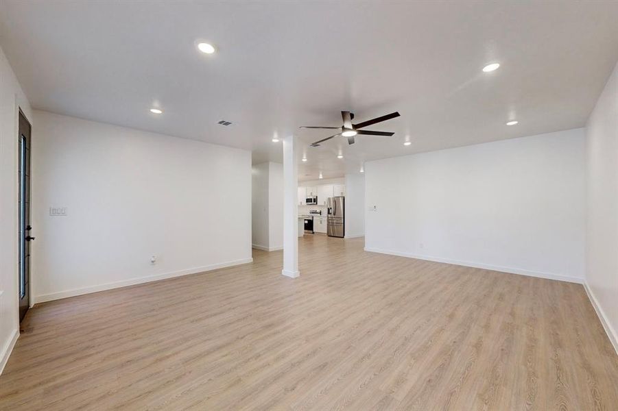 Unfurnished living room with ceiling fan and light hardwood / wood-style floors