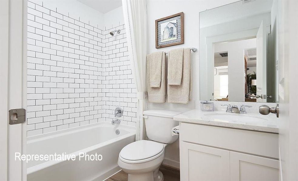 Full bathroom with vanity, toilet, and shower / bathtub combination with curtain