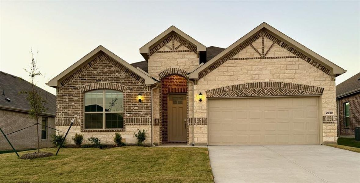 View of front of house with a front lawn and a garage