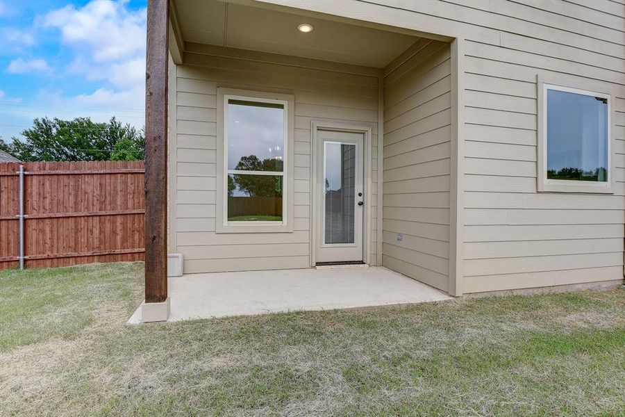 Doorway to property featuring a yard and a patio area