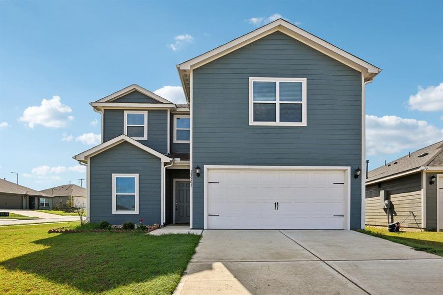 View of front of property with a garage and a front yard