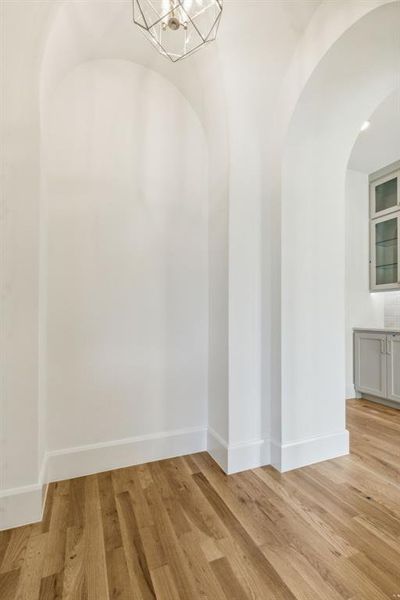 Spare room featuring a chandelier and light hardwood / wood-style floors