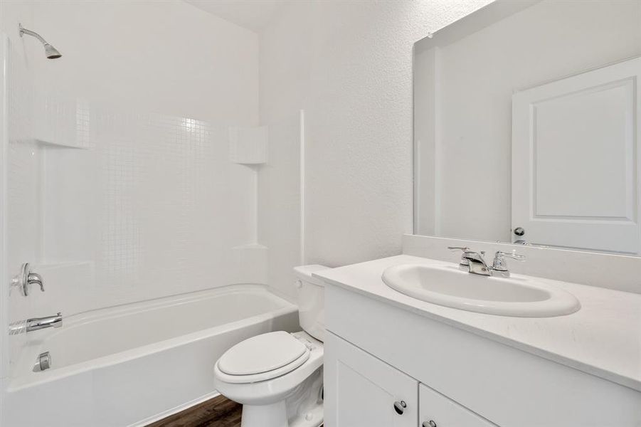 Full bathroom with wood-type flooring, vanity, toilet, and  shower combination