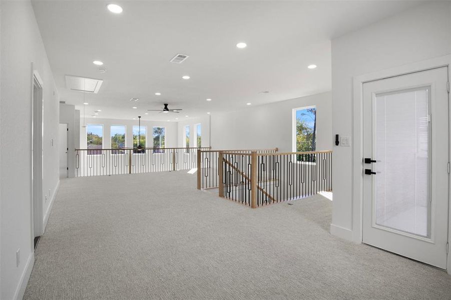 Hallway featuring light colored carpet