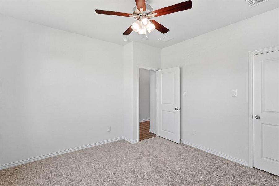 Unfurnished bedroom with light carpet and ceiling fan