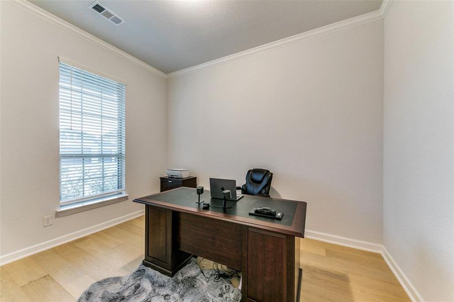 Office area with crown molding and light wood-type flooring