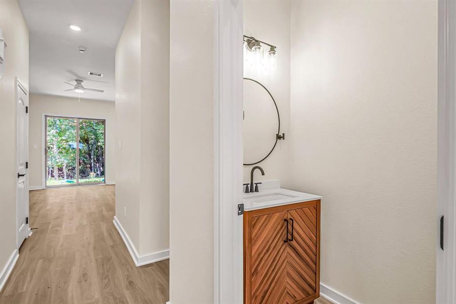 First floor powder room with stained wood vanity is conveniently located near the entry.