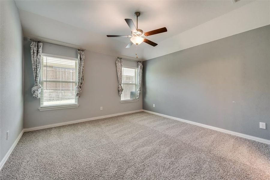 Spare room featuring carpet and ceiling fan