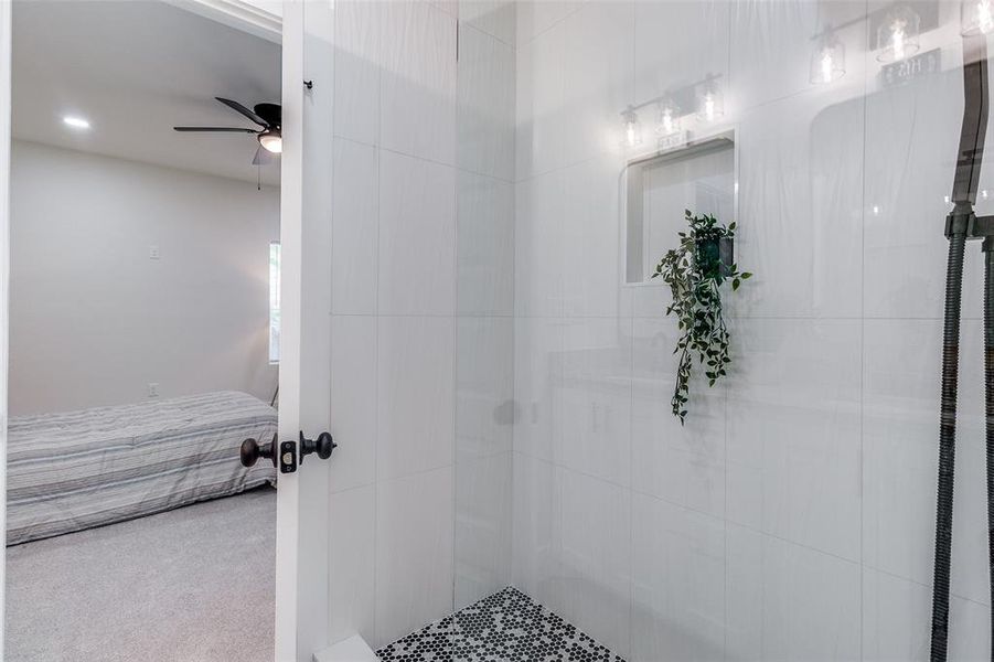 Bathroom with tiled shower and ceiling fan