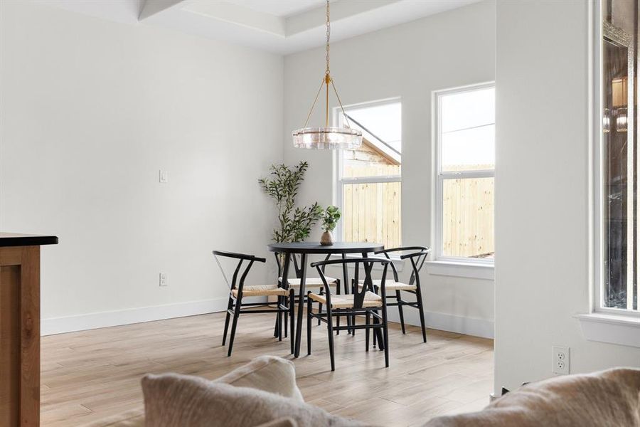 Dining space with light wood-type flooring and a chandelier