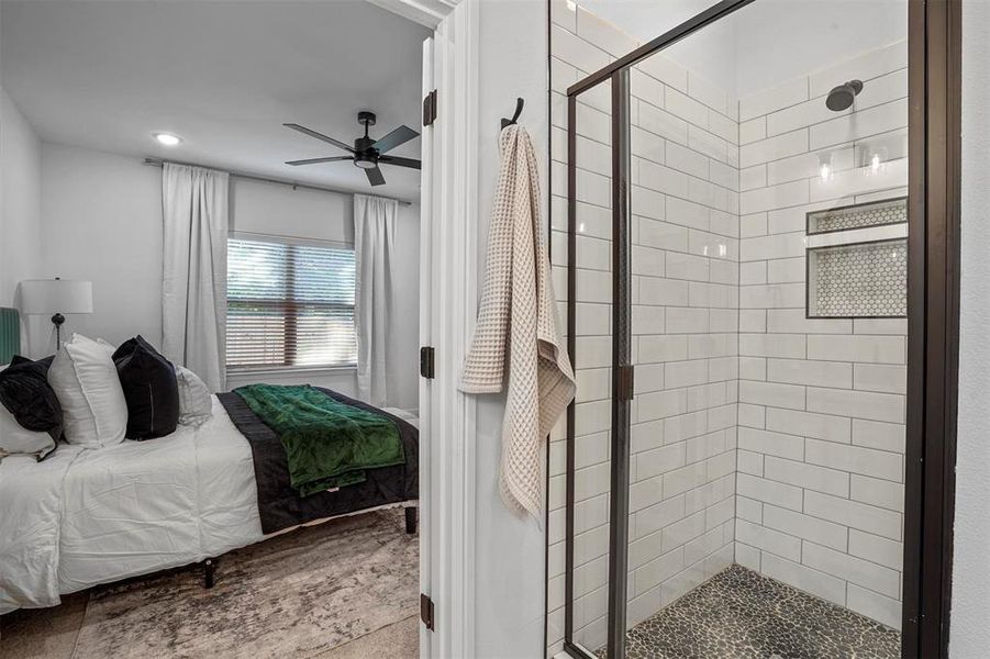 Bathroom with a shower with door and ceiling fan