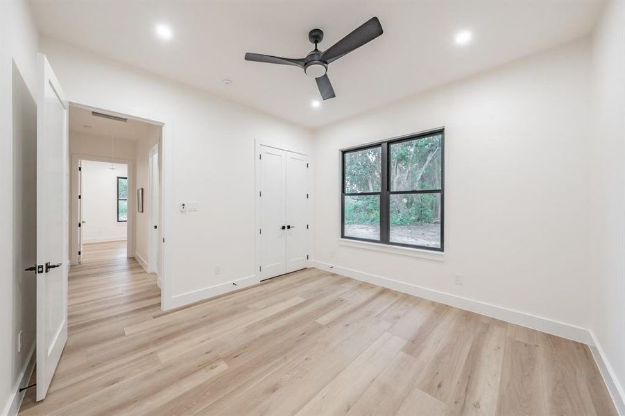 Spare room featuring ceiling fan and blonde plank, wood-like luxury vinyl floors.