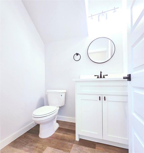 Bathroom featuring wood-type flooring, vanity, and toilet