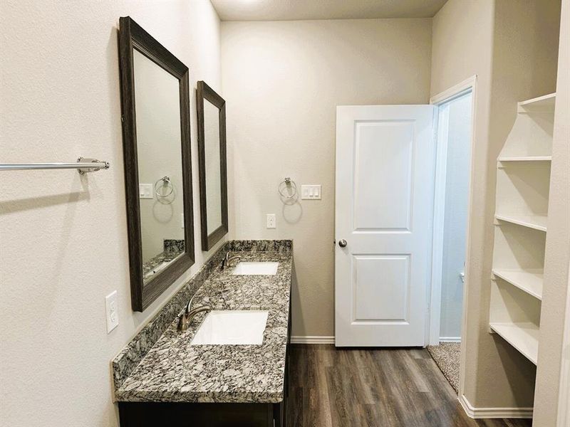 Double sinks in the en suite master bath + linen shelves, granite counters & framed mirrors!