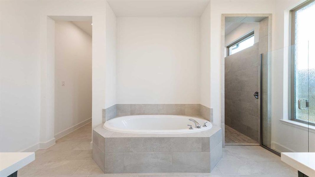 Bathroom featuring separate shower and tub, a healthy amount of sunlight, and tile patterned flooring