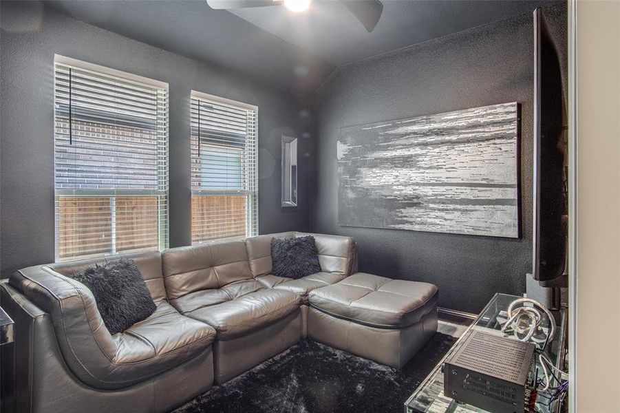 Living room with ceiling fan and lofted ceiling