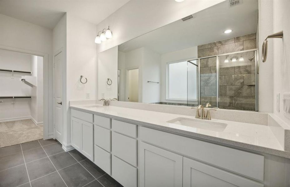 Elegant owner's bathroom with dual vanity *real home pictured