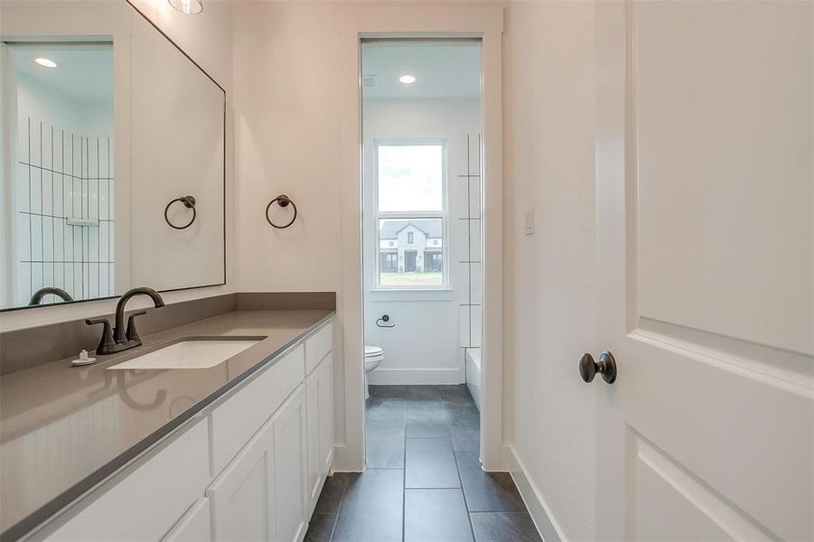 Full bathroom featuring vanity, toilet, tile patterned floors, and bathing tub / shower combination