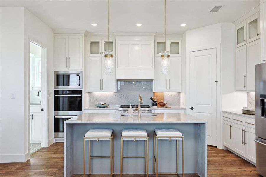 Kitchen featuring an island with sink, stainless steel appliances, tasteful backsplash, and dark wood-type flooring