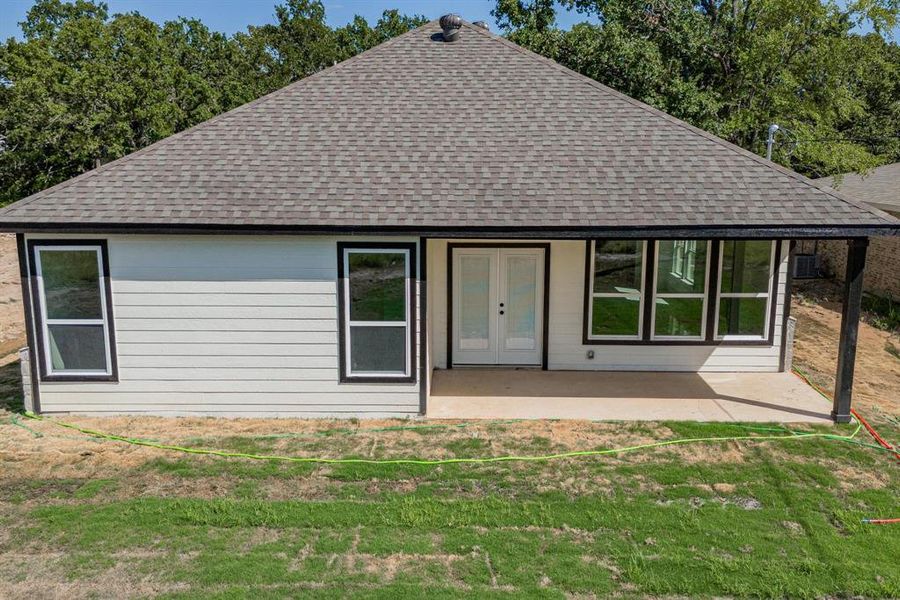 Rear view of property with a patio and a lawn