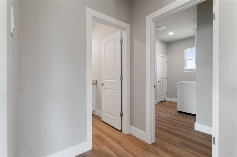 Hall with wood-type flooring and washer / clothes dryer