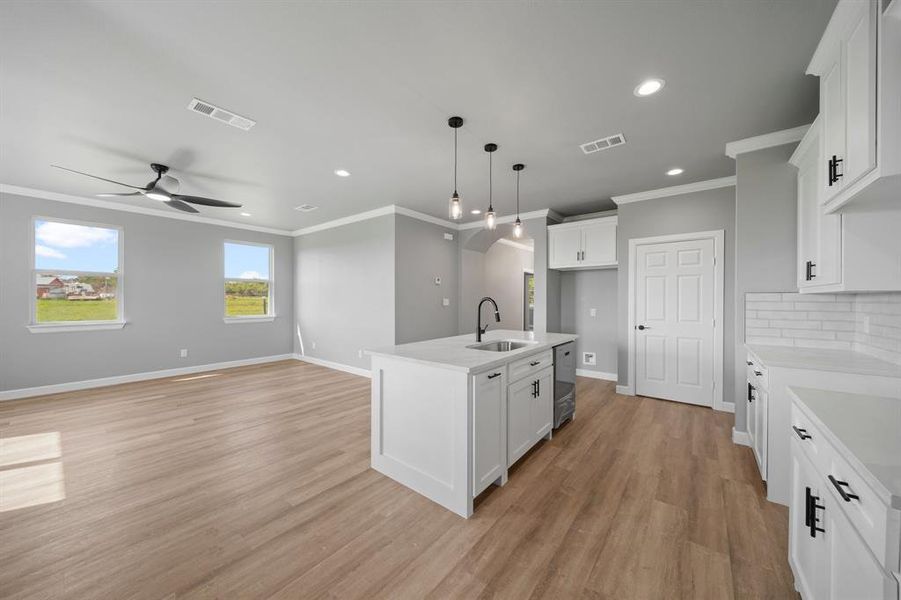 Kitchen featuring white cabinetry, sink, light wood-type flooring, and ceiling fan