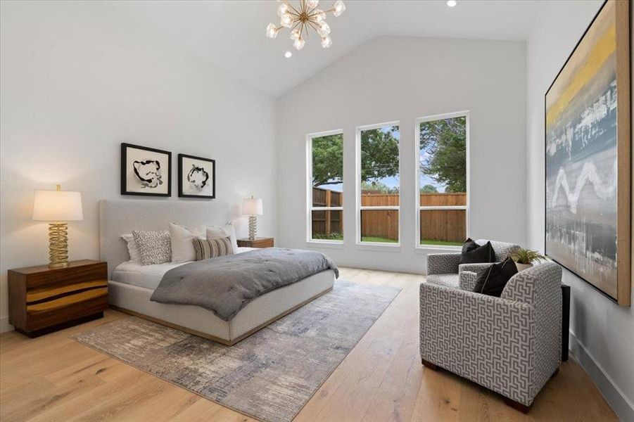 Bedroom featuring wood-type flooring, high vaulted ceiling, and a notable chandelier