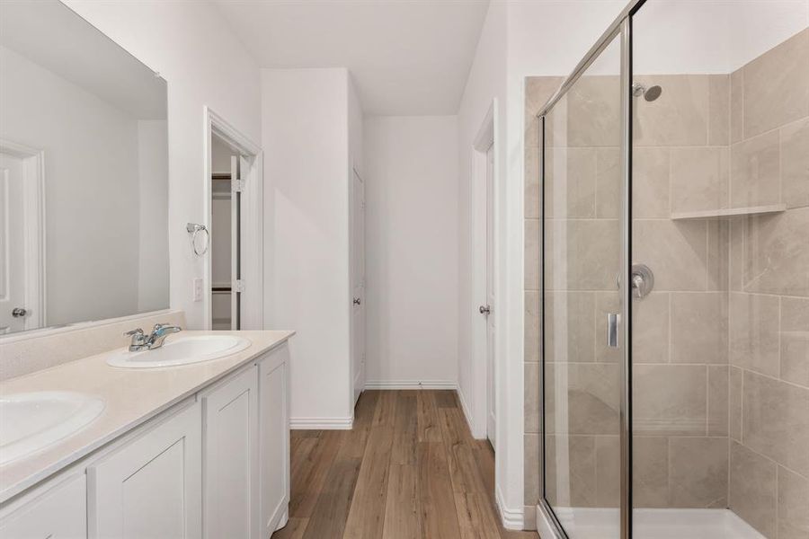 Bathroom featuring an enclosed shower, hardwood / wood-style flooring, and double sink vanity