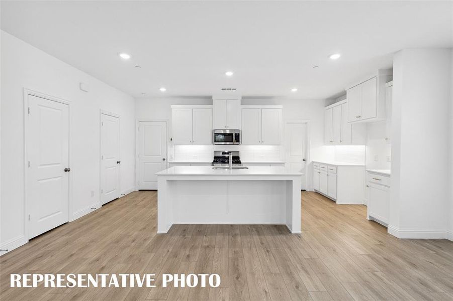 The large kitchen island creates the perfect gathering place for family and friends!  REPRESENTATIVE PHOTO