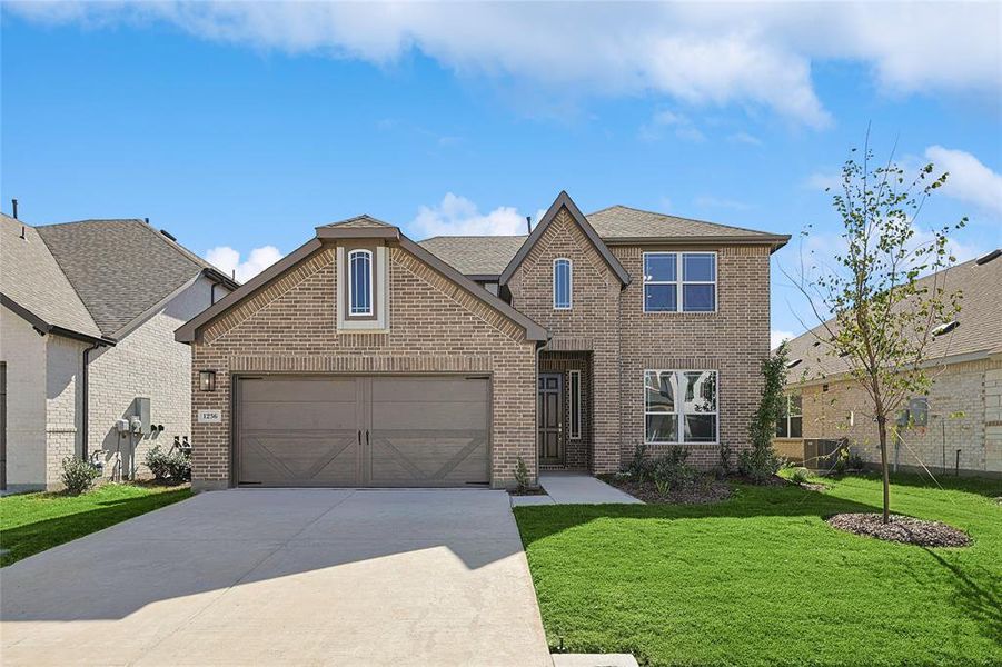 View of front of home featuring a front lawn and a garage