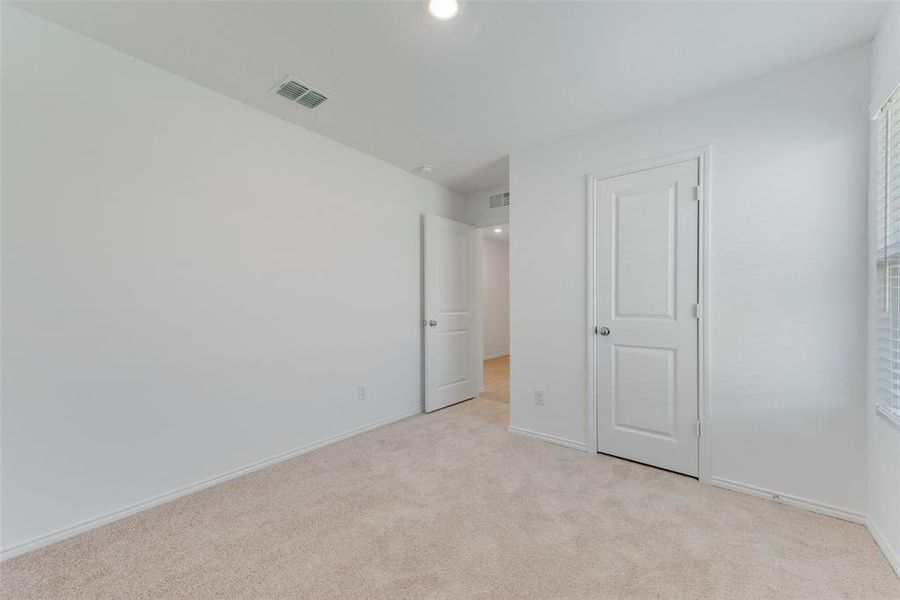 Unfurnished bedroom featuring light carpet