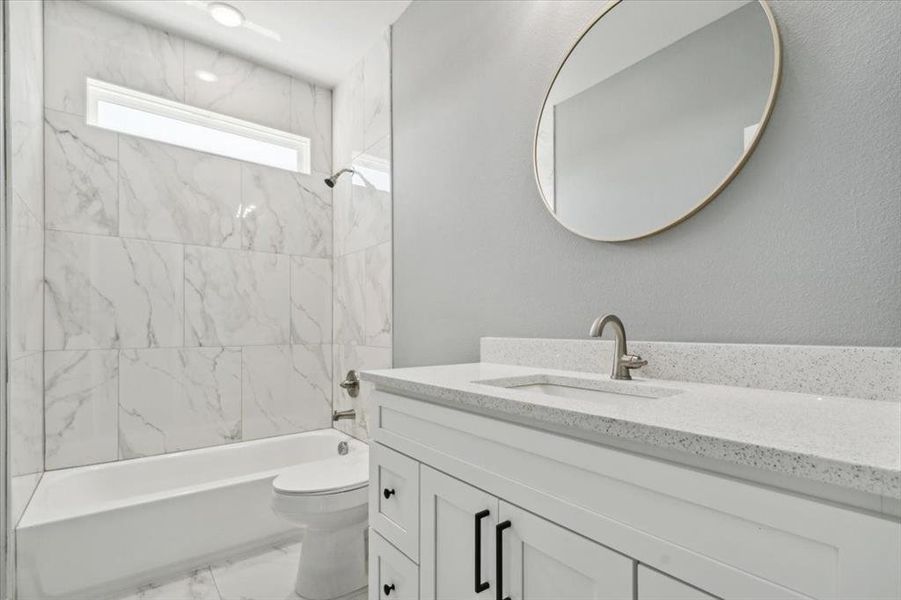 Full bathroom with vanity, toilet, and tiled shower / bath