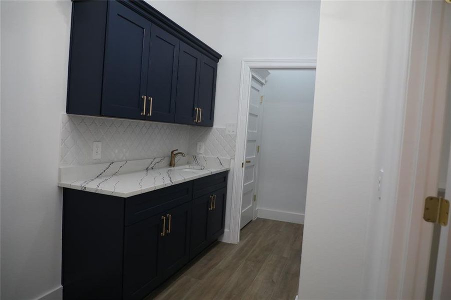 Utility room has a wash sink, soft close cabinets, granite tops and back splash.