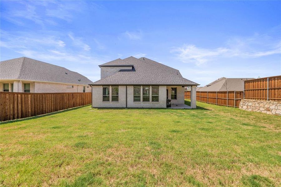 Rear view of property featuring a patio and a yard